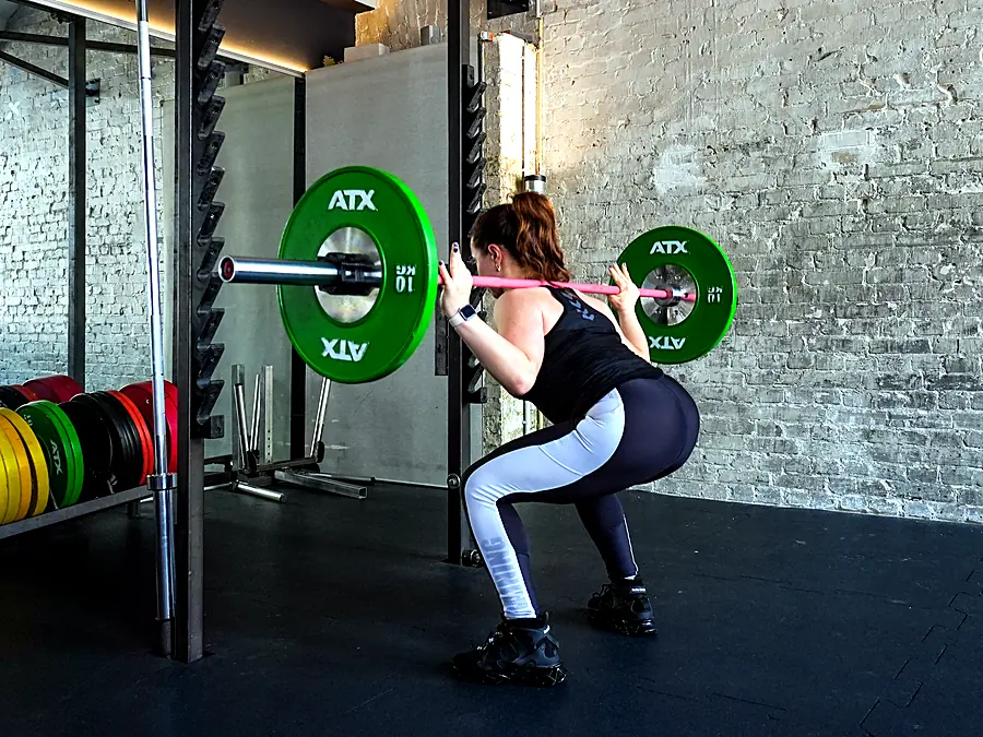 Barbell squat in front of a brick wall at Lokahi Loft Berlin