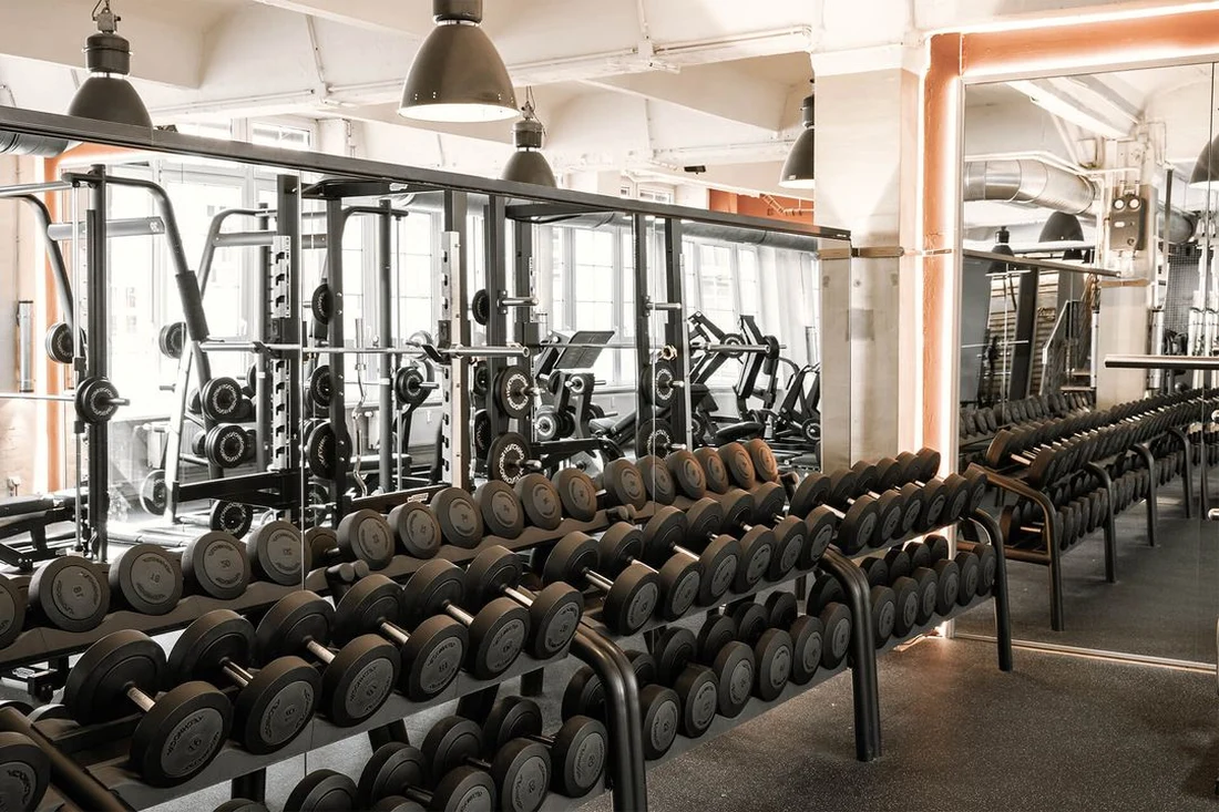 Dumbbell rack with mirrored wall in the free-weight area at Lokahi Loft Berlin