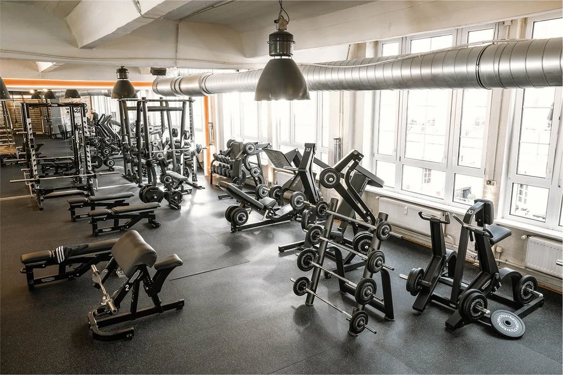 Spacious training floor with strength machines and free-weight zone at Lokahi Loft Berlin