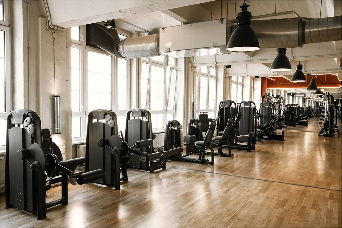 Row of strength machines along the window front at Lokahi Loft Berlin