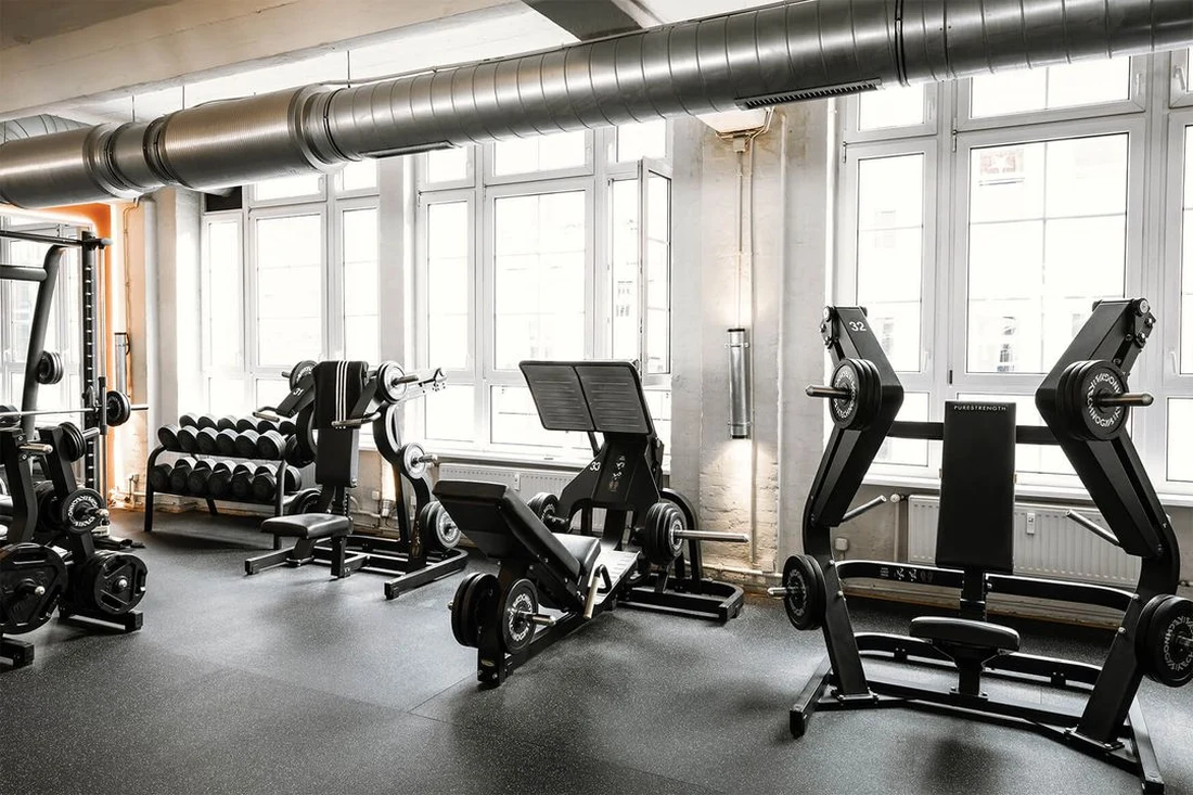 Row of strength machines with accent lighting at Lokahi Loft Berlin