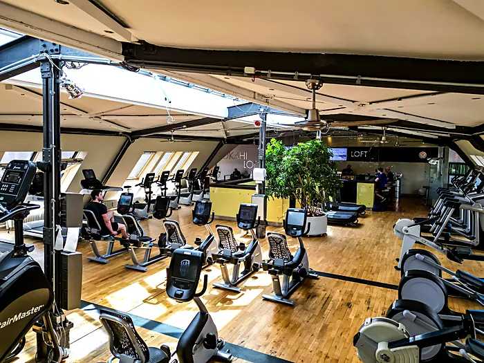 Bright fitness area with cardio machines at Lokahi Loft Berlin