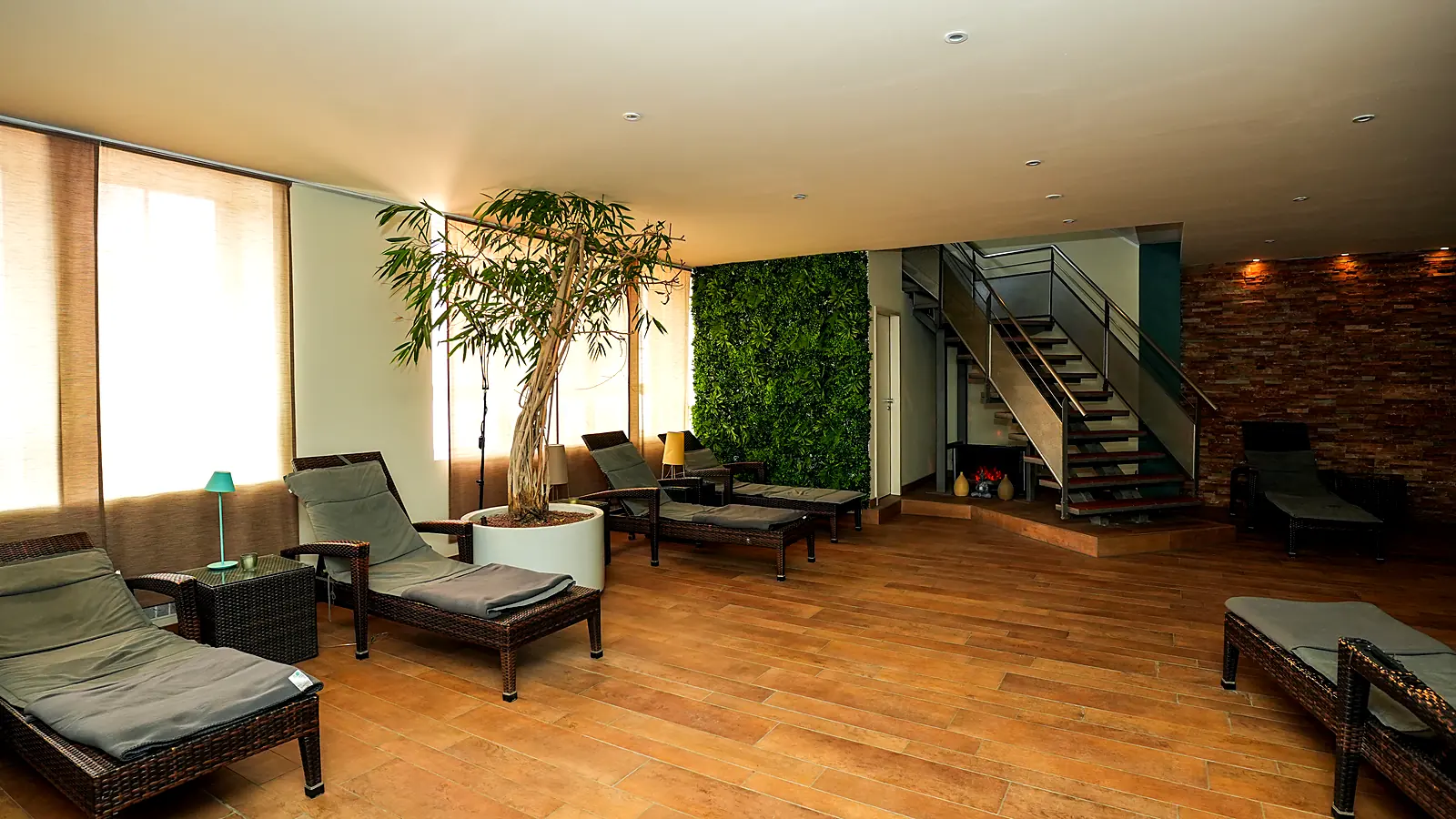 Wellness lounge with fireplace and rattan loungers at Lokahi Loft Berlin
